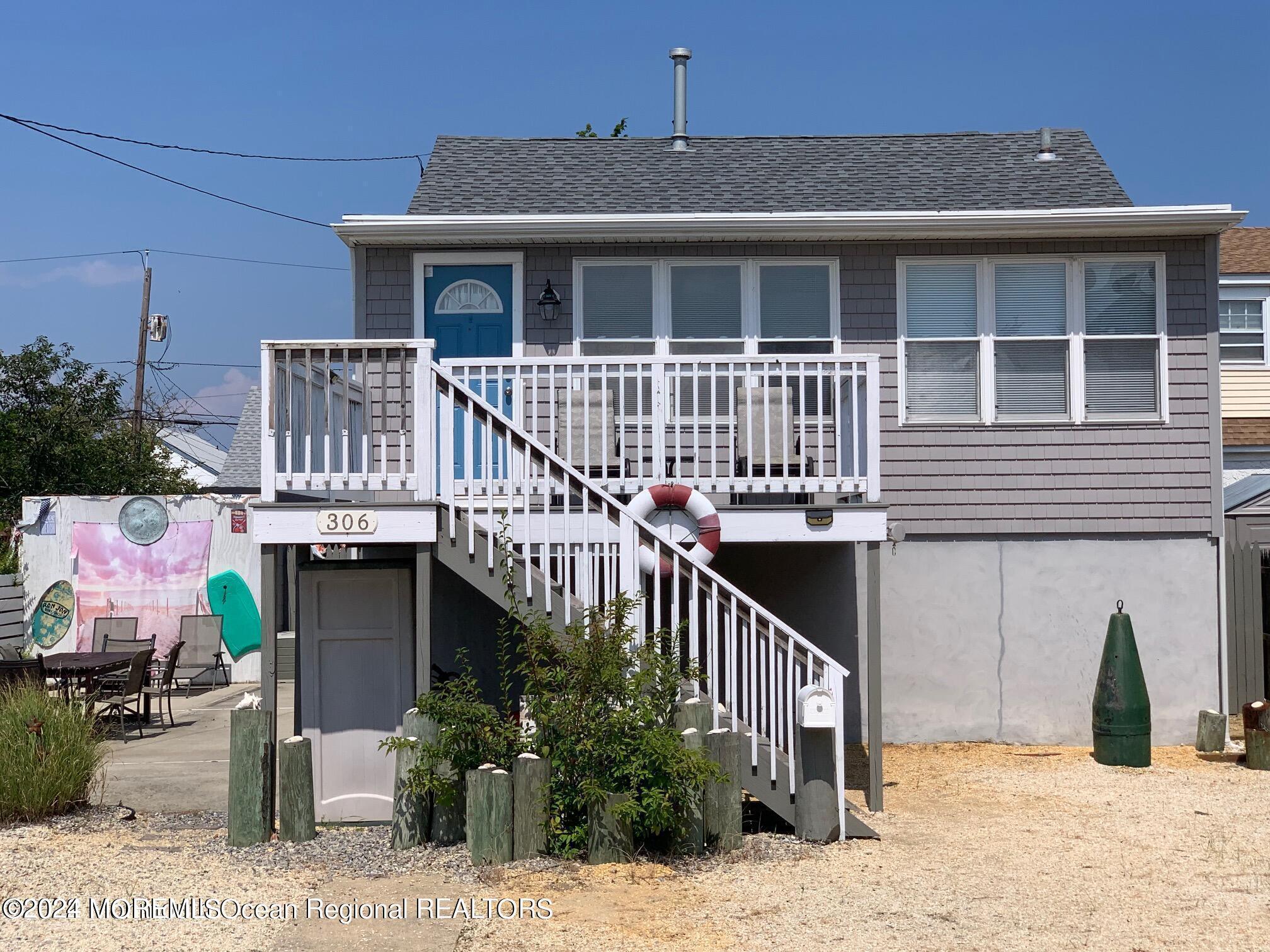 a view of a house with wooden deck and furniture