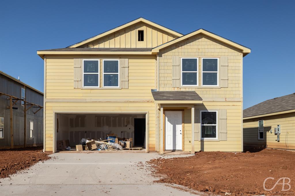 a front view of a house with yard and parking space