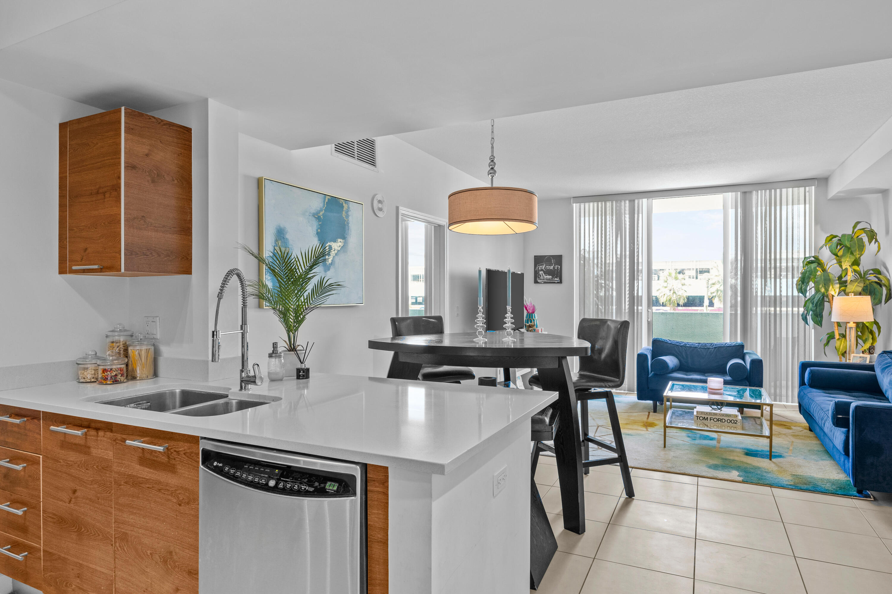 a kitchen with a sink a counter and chairs in it