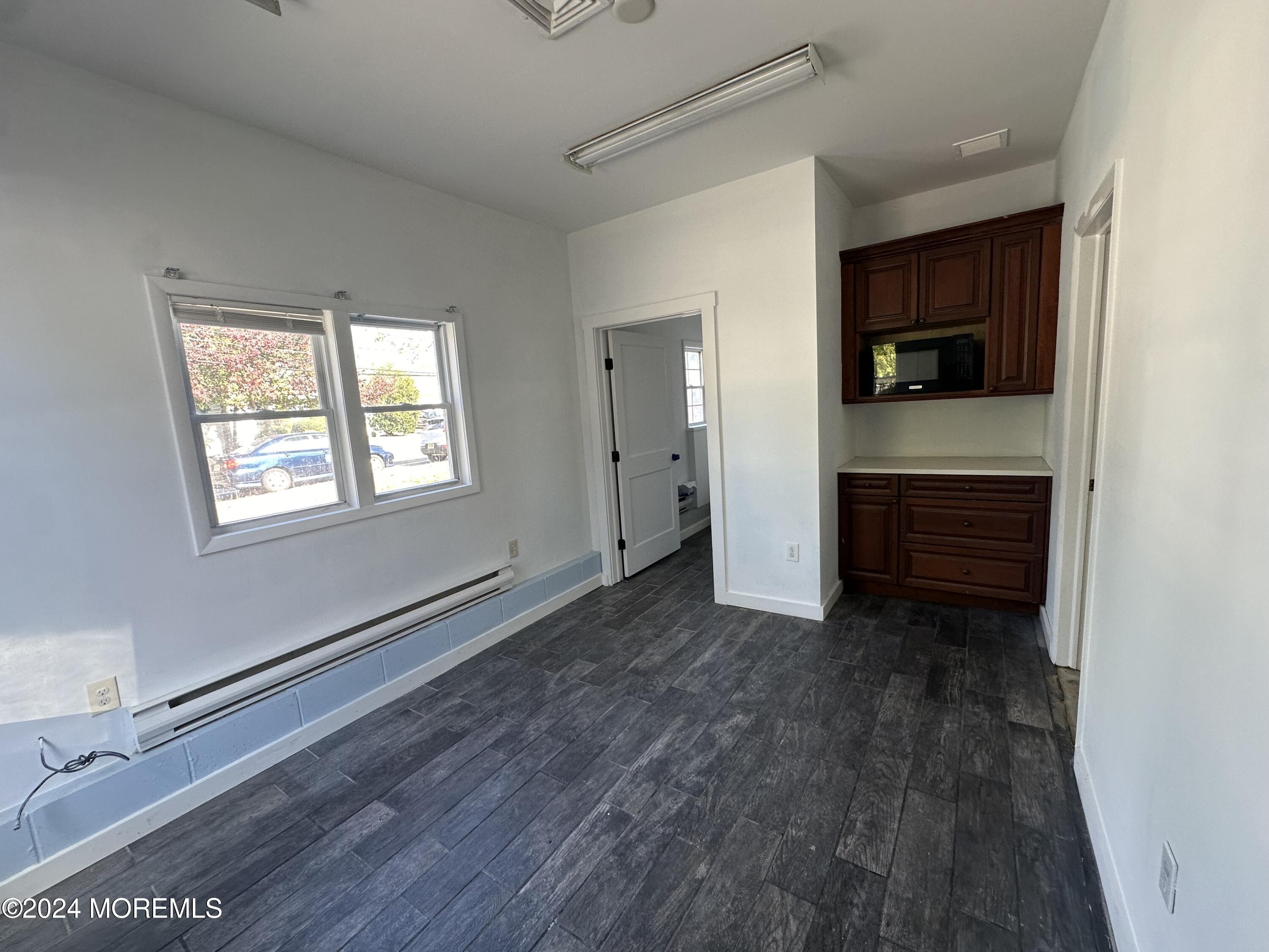 a view of a livingroom with wooden floor and a window