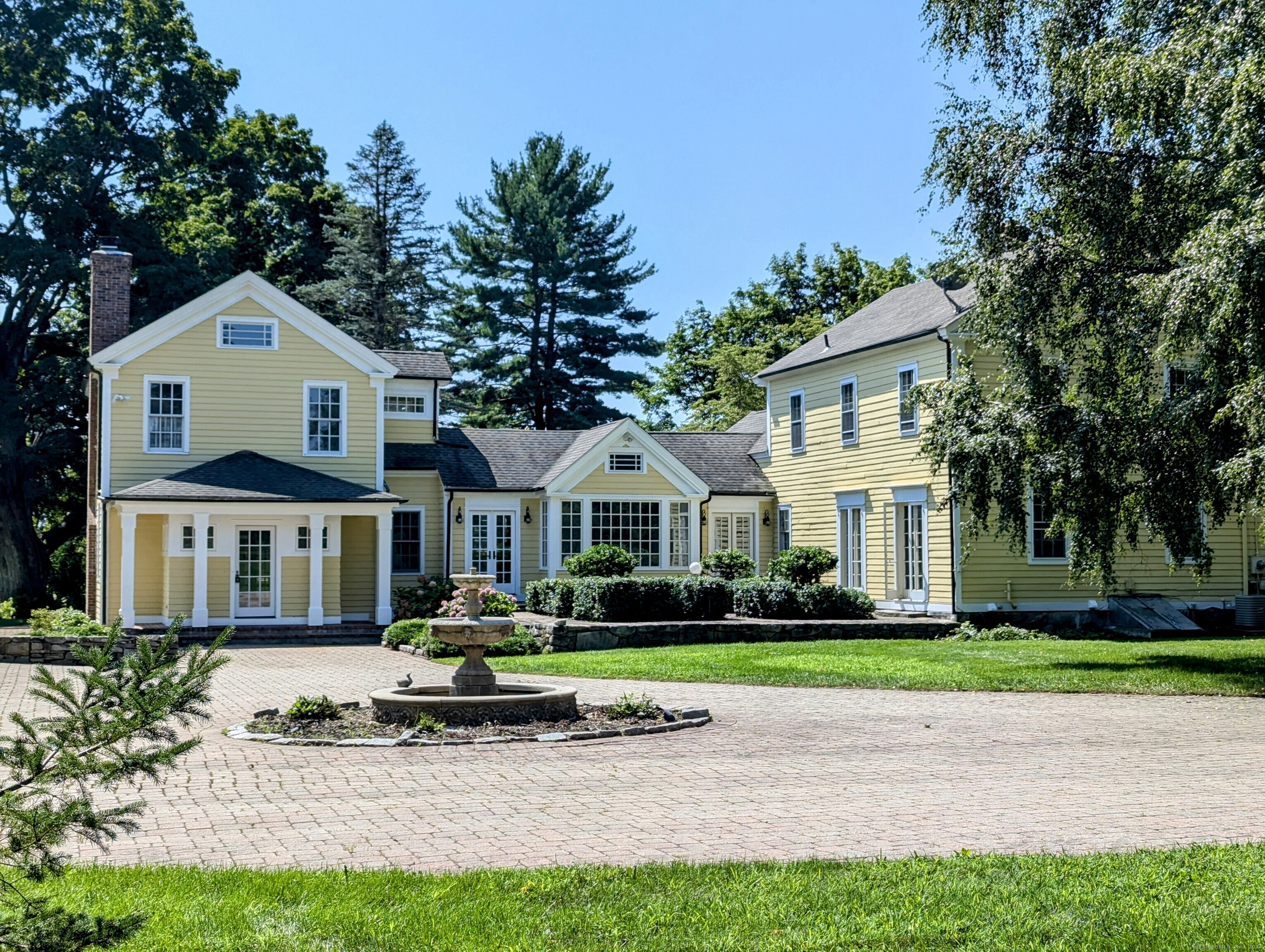 a front view of a house with a garden and trees