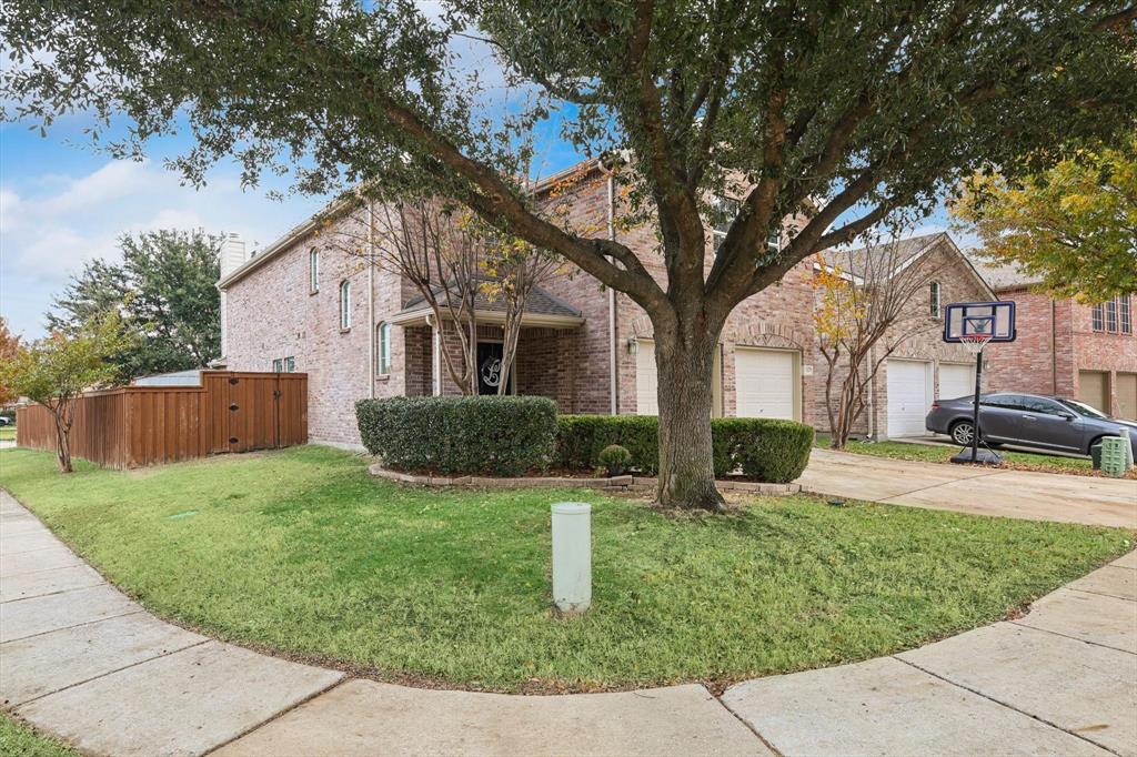 a view of backyard of house with wooden fence and large trees