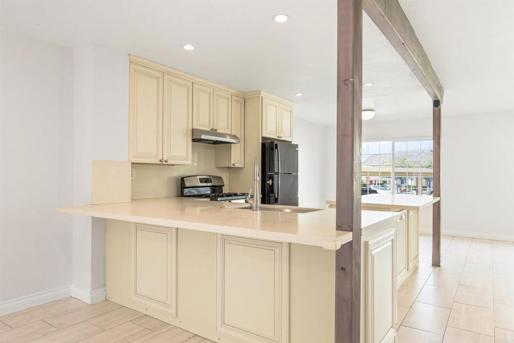 a kitchen with white cabinets and refrigerator