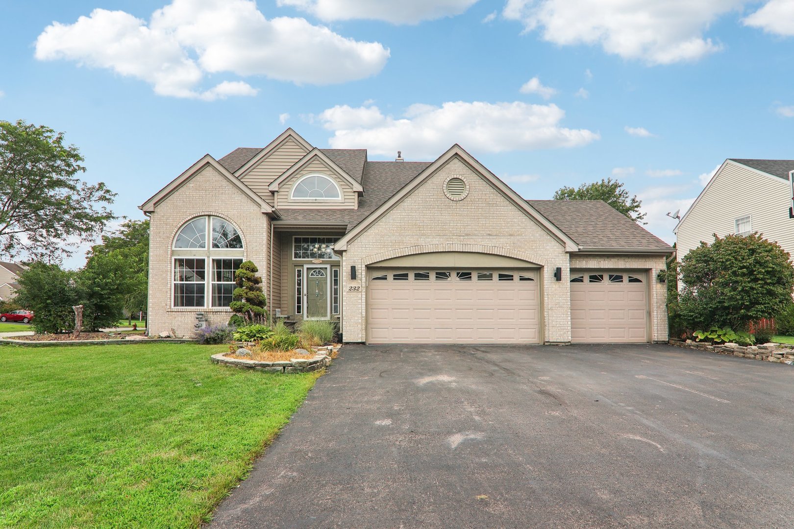 a front view of a house with a yard and garage