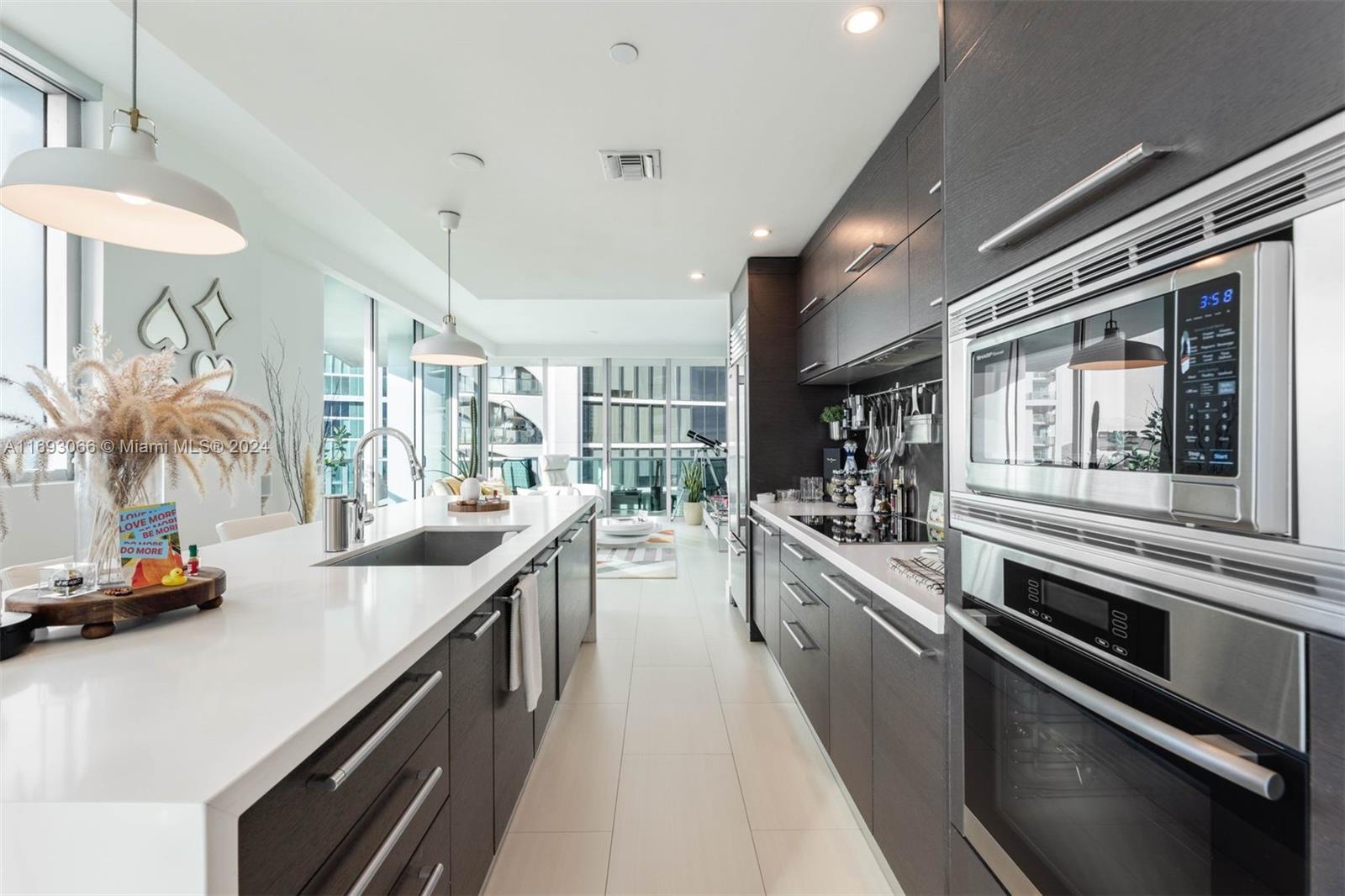 a large kitchen with stainless steel appliances lots of counter space and a sink