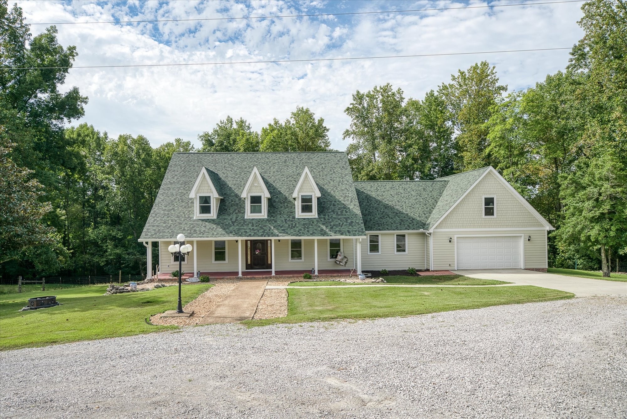 a view of front a house with a big yard and large trees