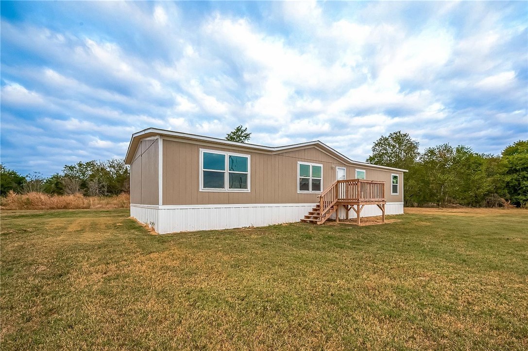 Back of property with a lawn