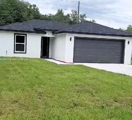 a front view of house with yard and trees in the background