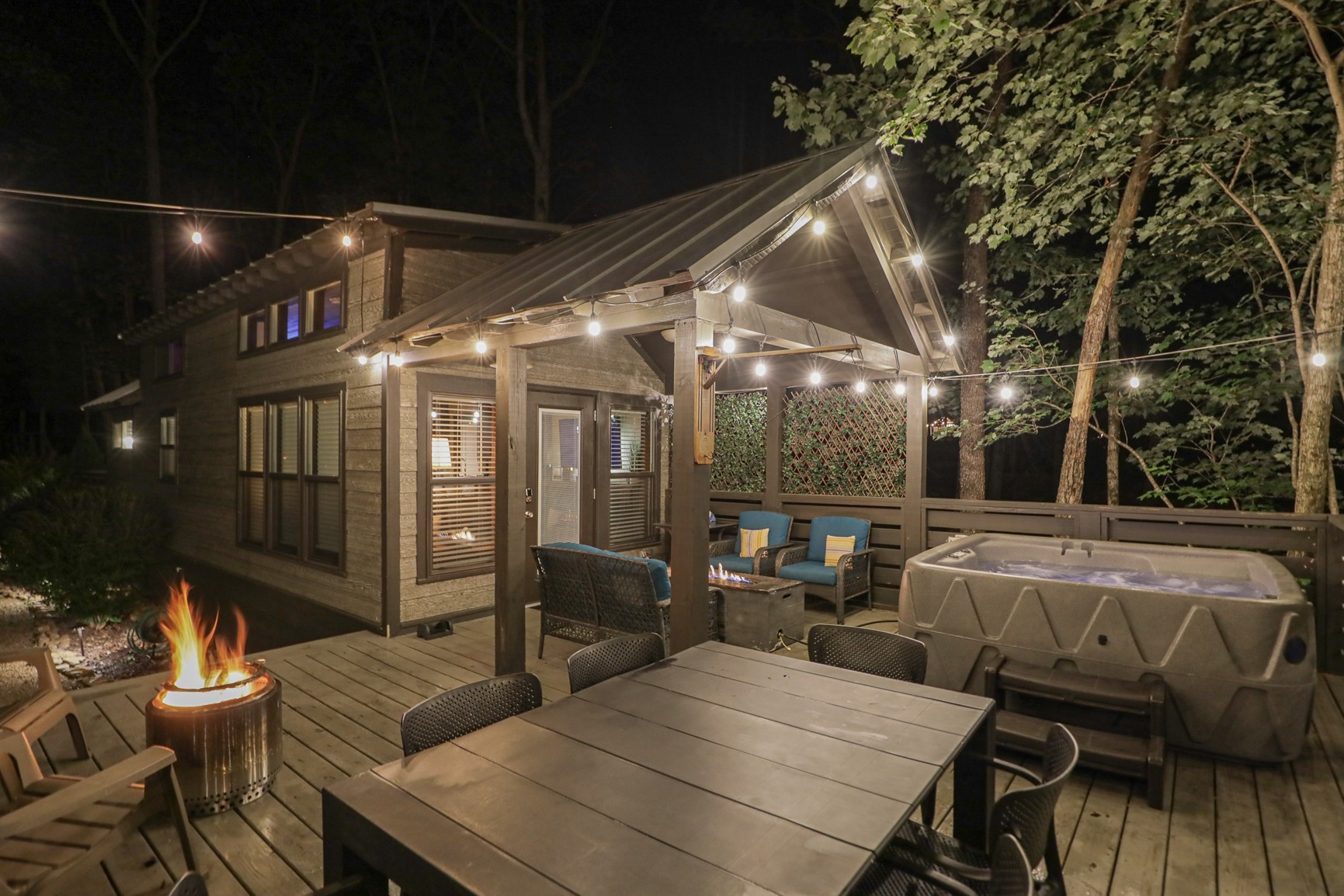 a roof deck with table and chairs and potted plants