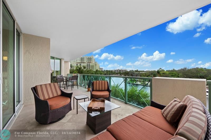 a balcony with furniture and a floor to ceiling window