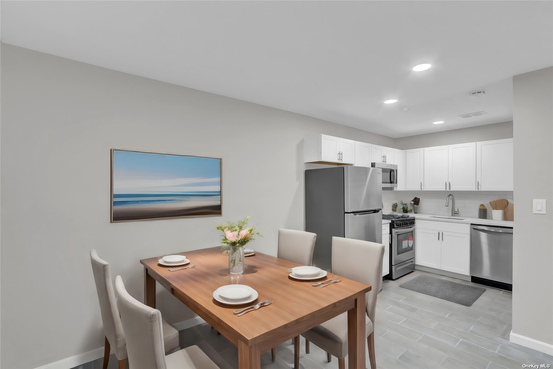 a kitchen with stainless steel appliances kitchen island granite countertop a dining table and chairs