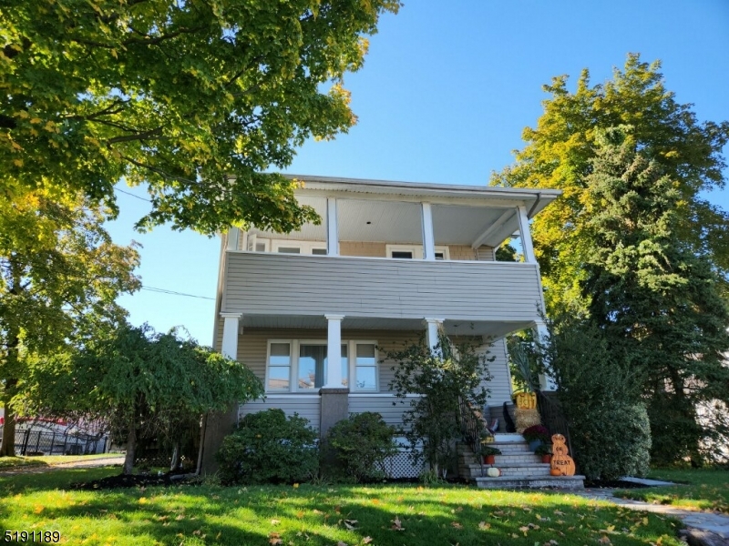 a front view of a house with a garden and swimming pool