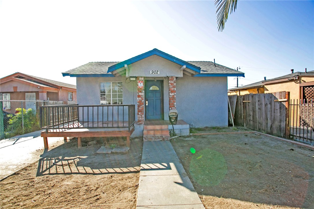 a view of a house with a small yard and wooden floor and fence