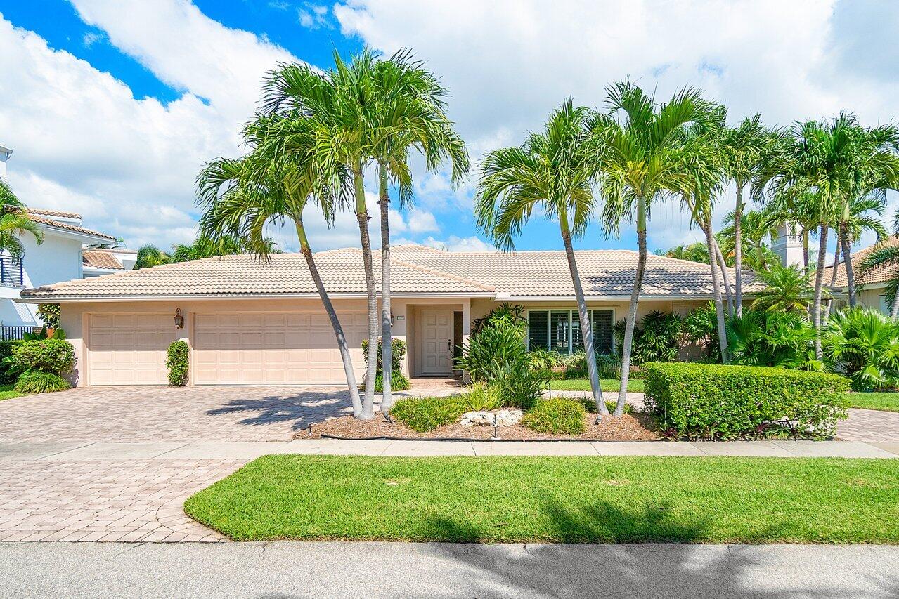 a view of a house with a yard and palm trees