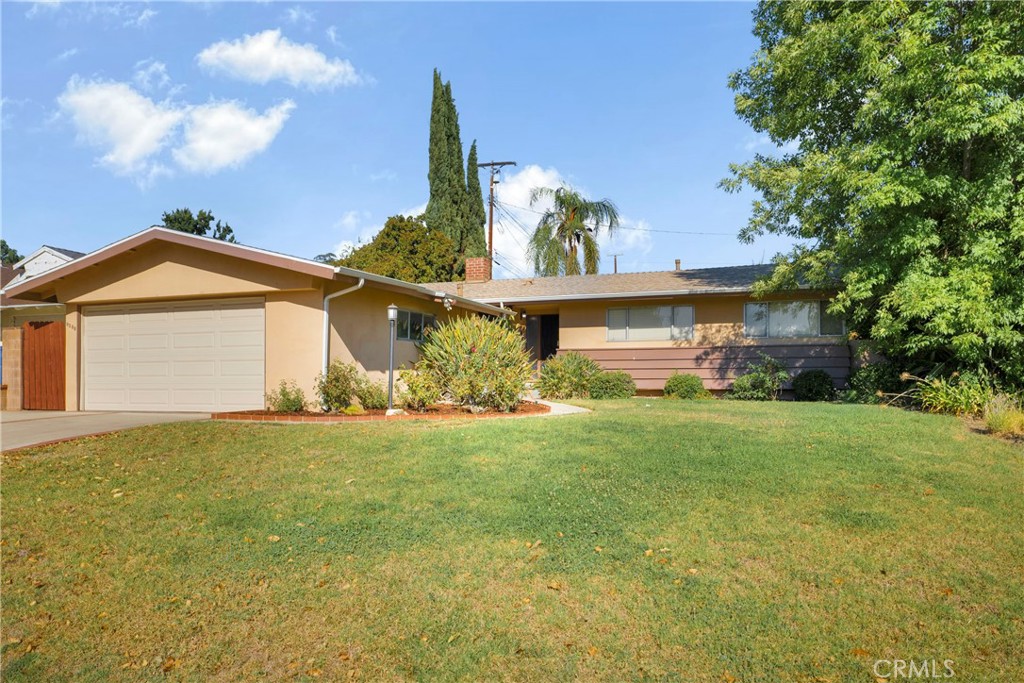 a view of a house with a yard and garage