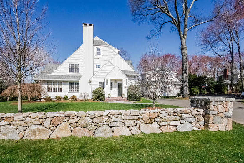 a view of a white house with a yard and plants