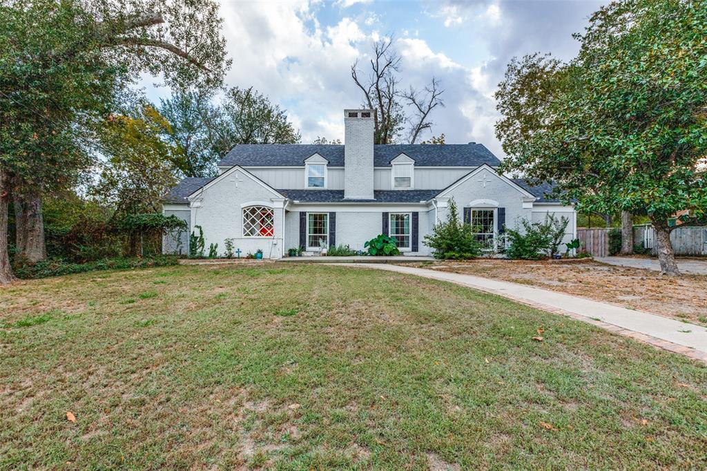 a front view of house with yard and trees around