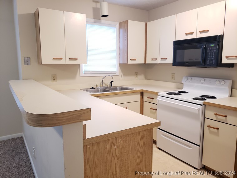 a kitchen with stainless steel appliances white cabinets a sink and a stove