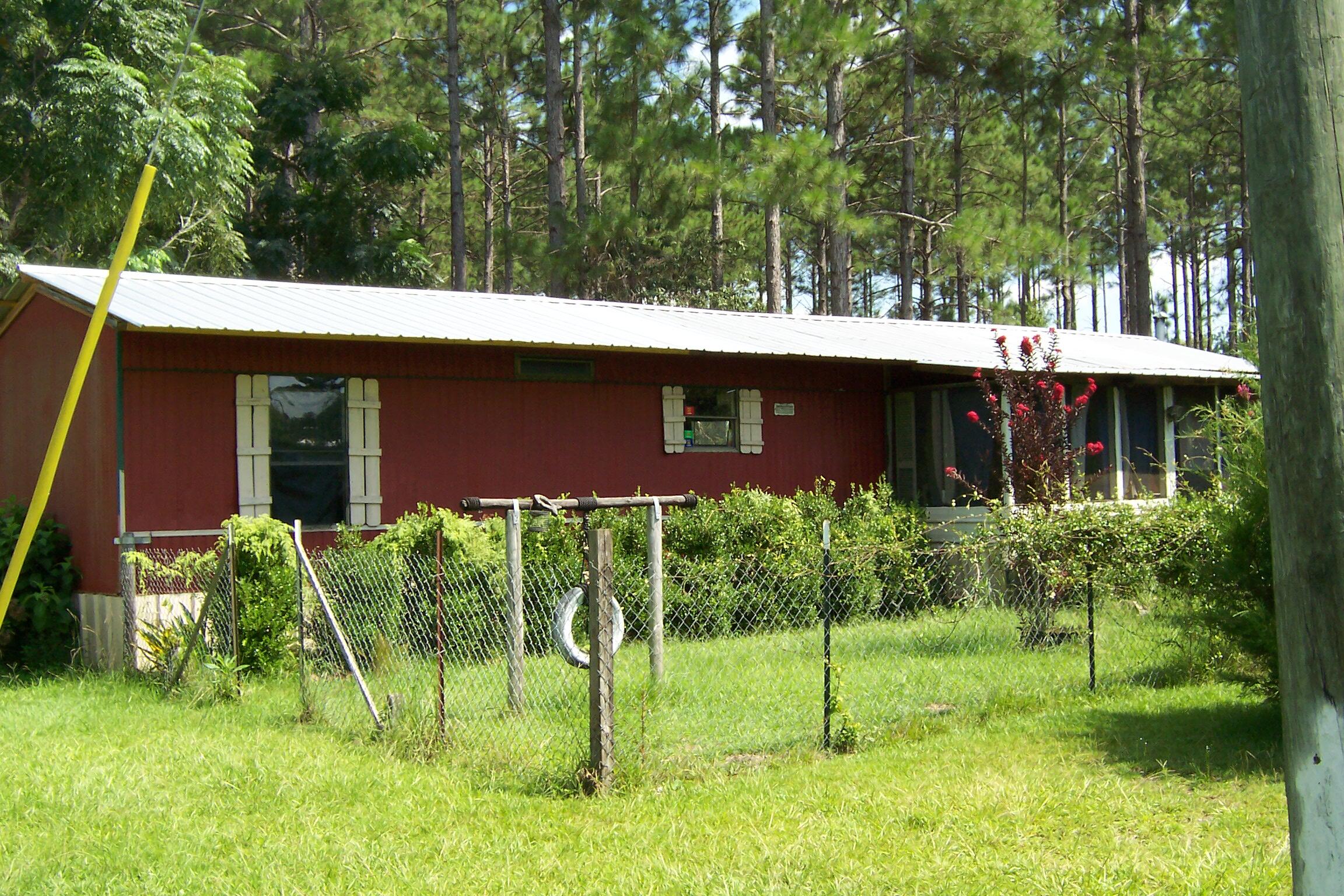 a view of house with a yard and plants