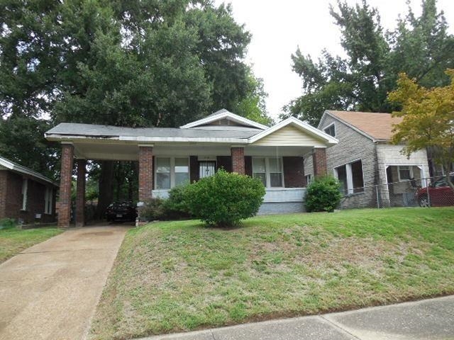 View of front of property with a carport and a front yard