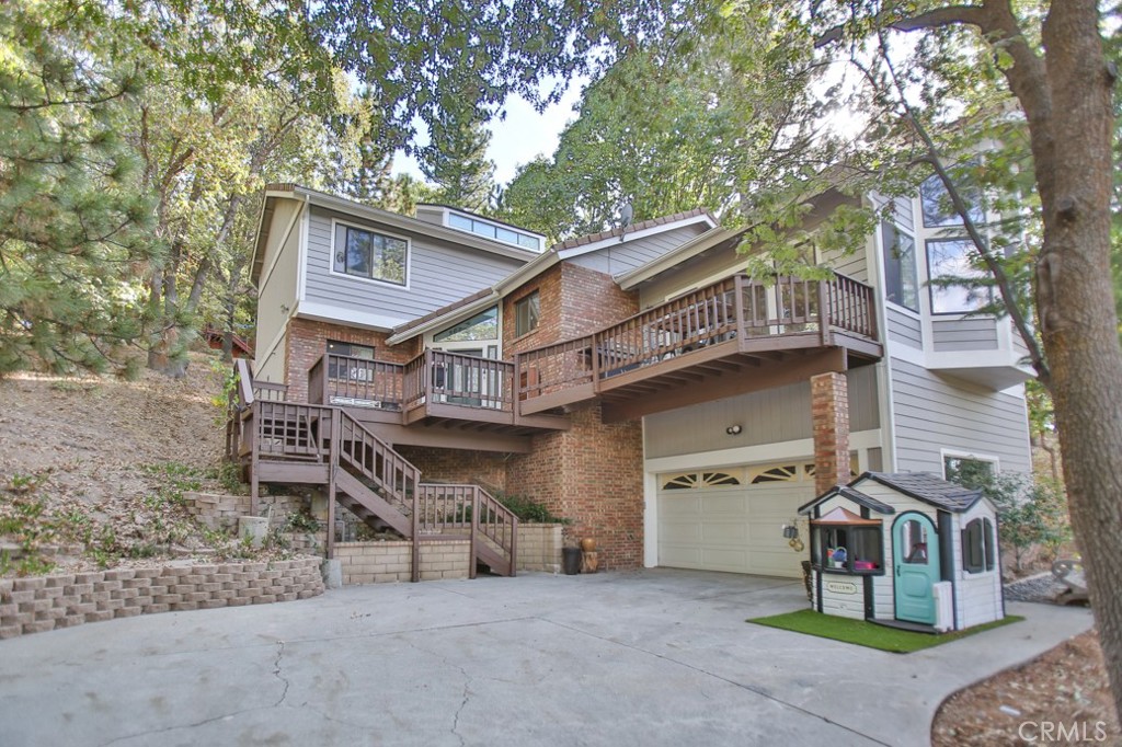 a view of a house with a wooden fence and large trees