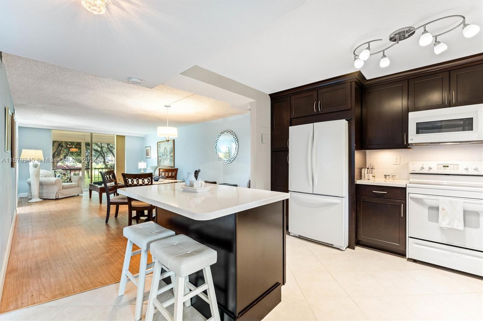 a kitchen with stainless steel appliances kitchen island a table chairs in it and wooden floors