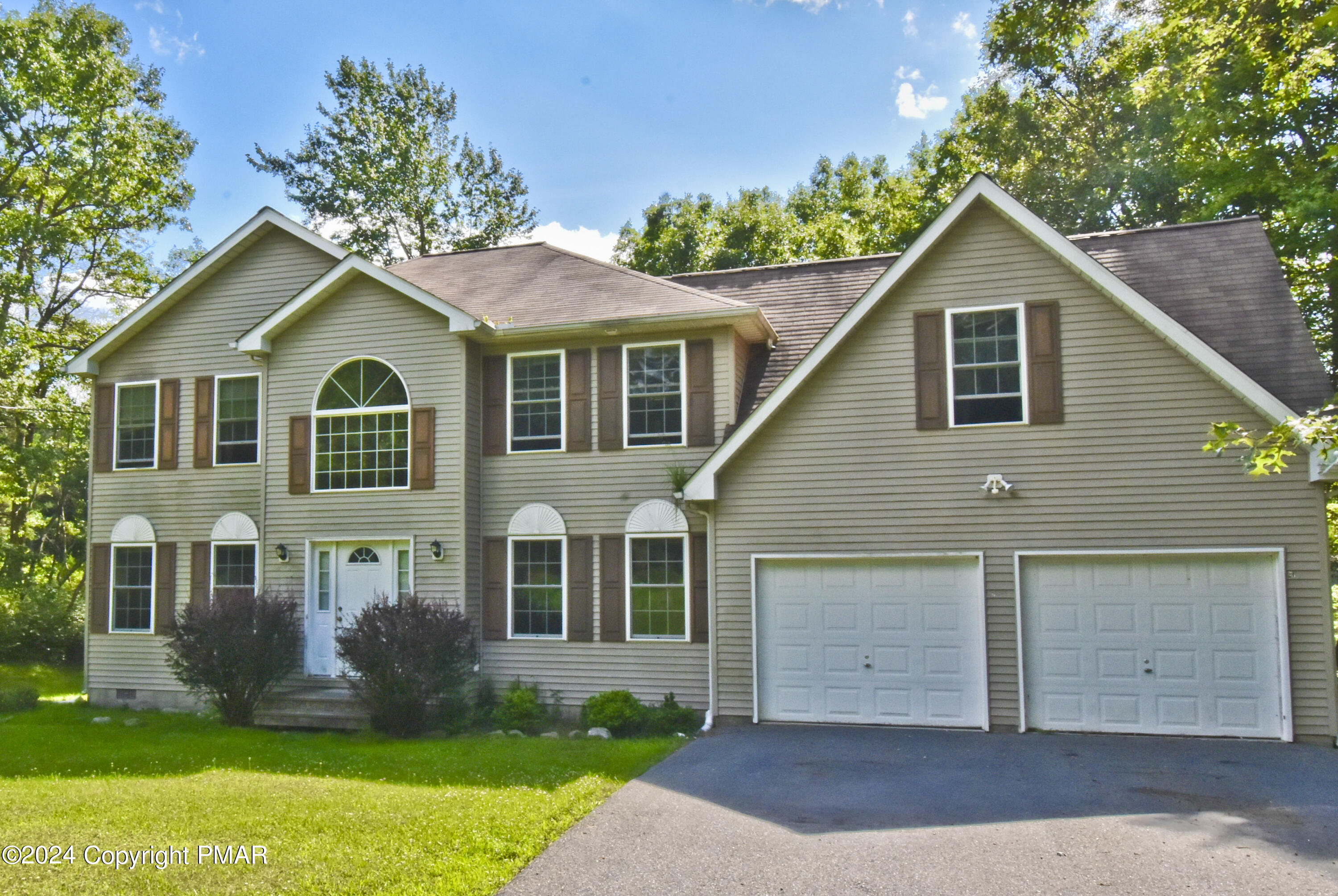 a front view of a house with a yard and garage