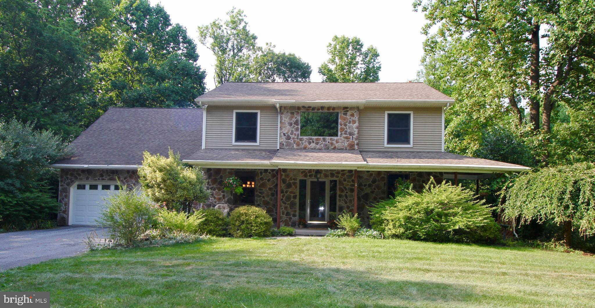 a front view of a house with a yard and green space