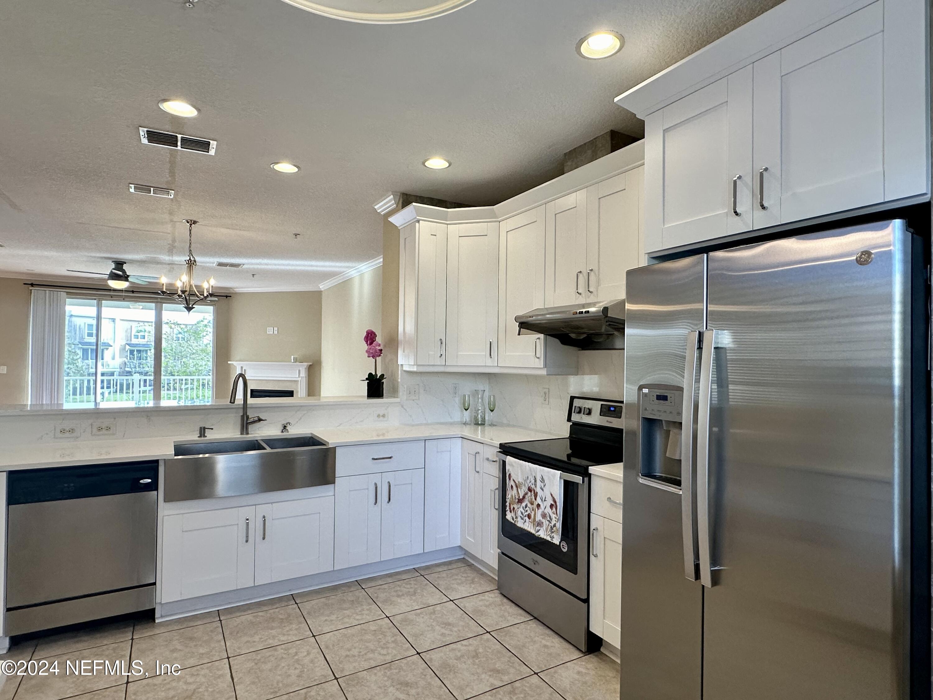 a kitchen with granite countertop a refrigerator stove top oven and sink