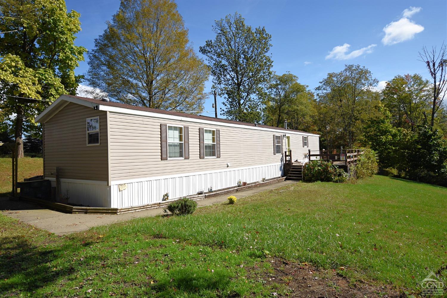 a view of a house with backyard and trees