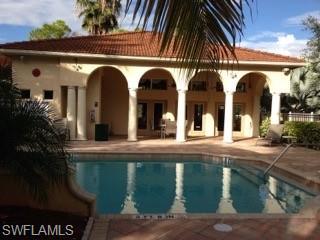 a view of pool with dining table and chairs