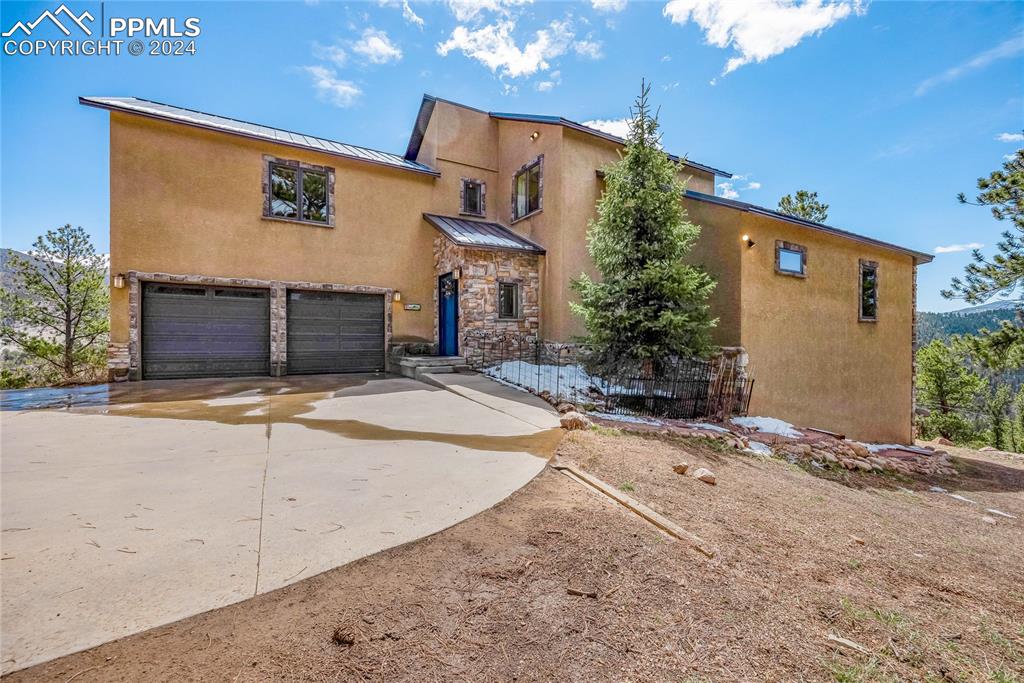 View of front entrance to home featuring a two-car garage.