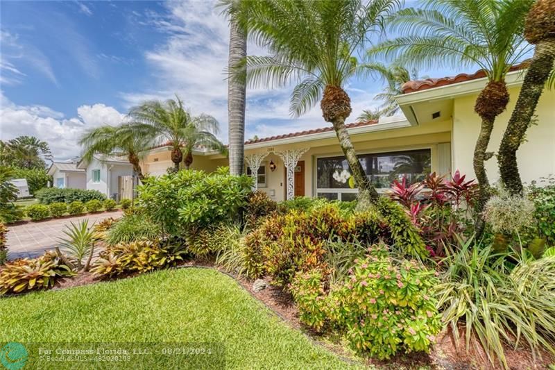 front view of house with a yard and potted plants