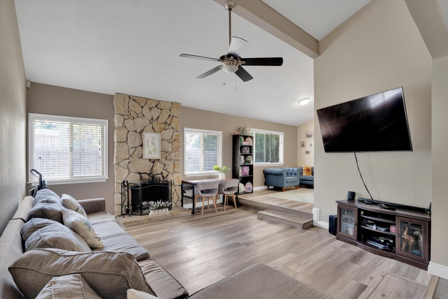 a living room with furniture a flat screen tv and a large window