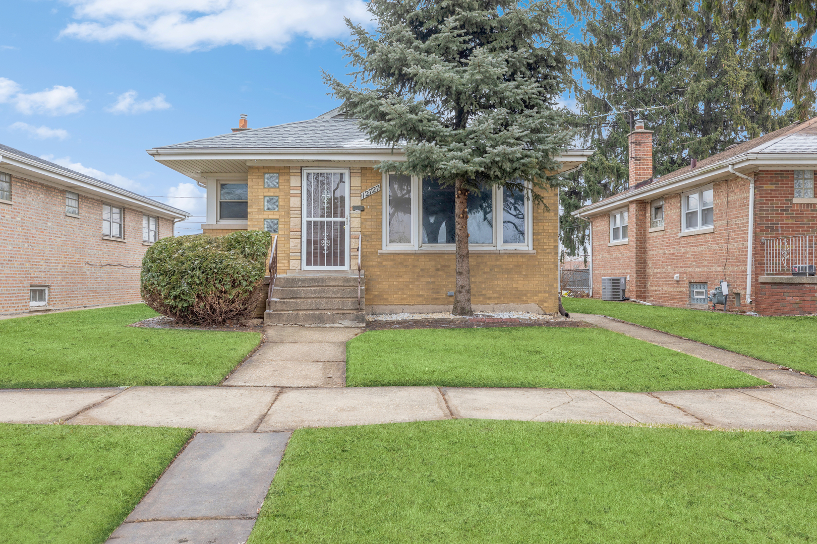 a front view of a house with a garden and plants