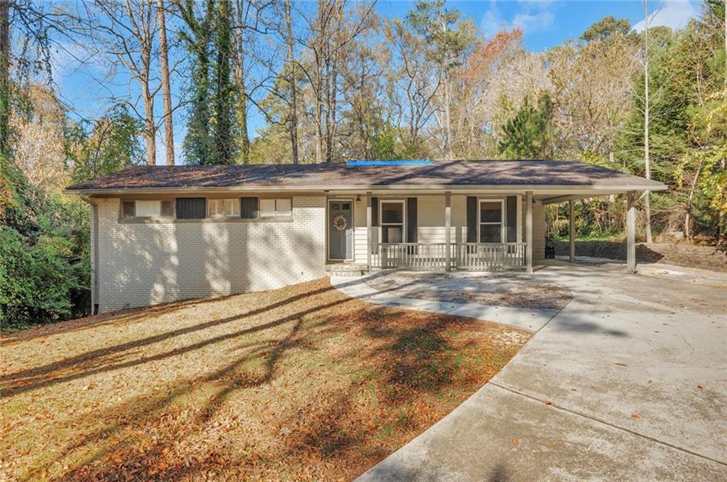 a backyard of a house with large trees and barbeque oven