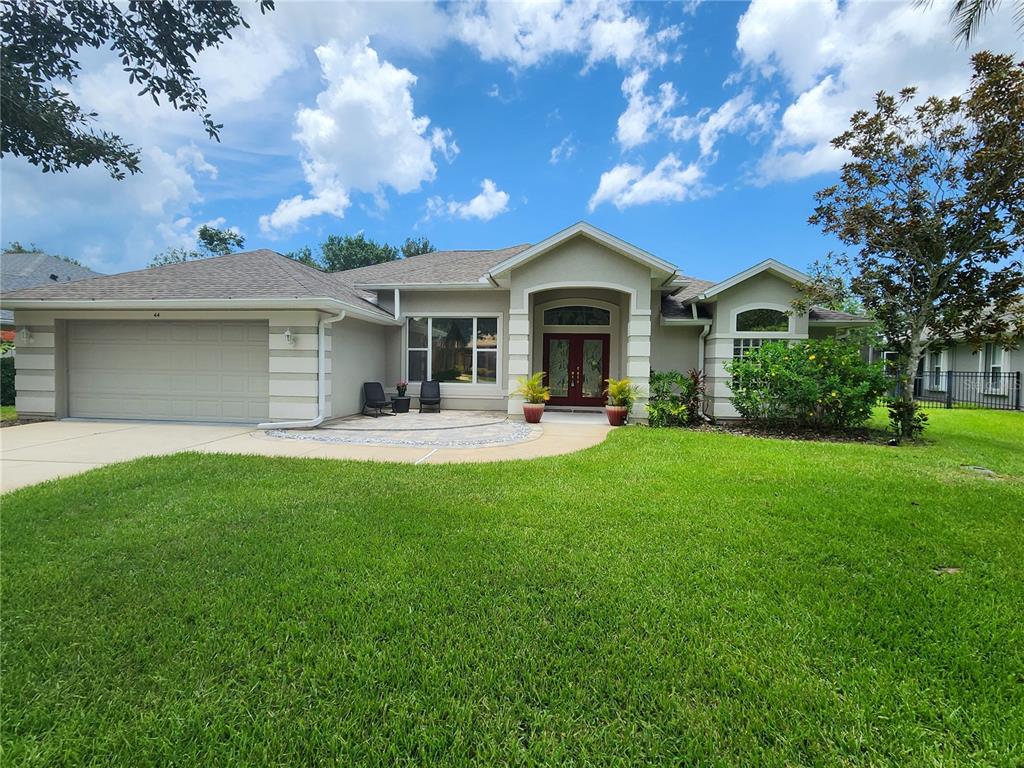 a front view of a house with yard and green space