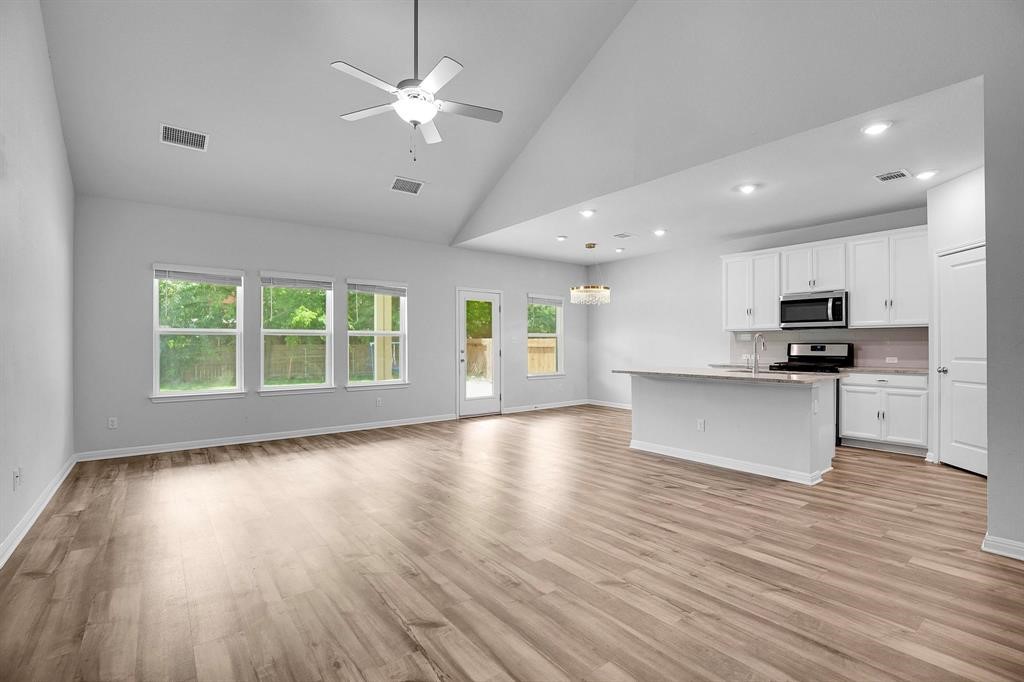 a view of kitchen with microwave a stove and wooden floor