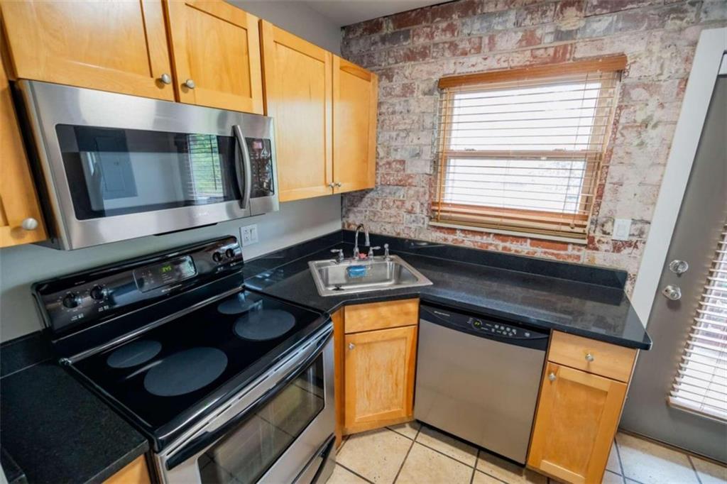 a kitchen with granite countertop stainless steel appliances a stove sink and microwave