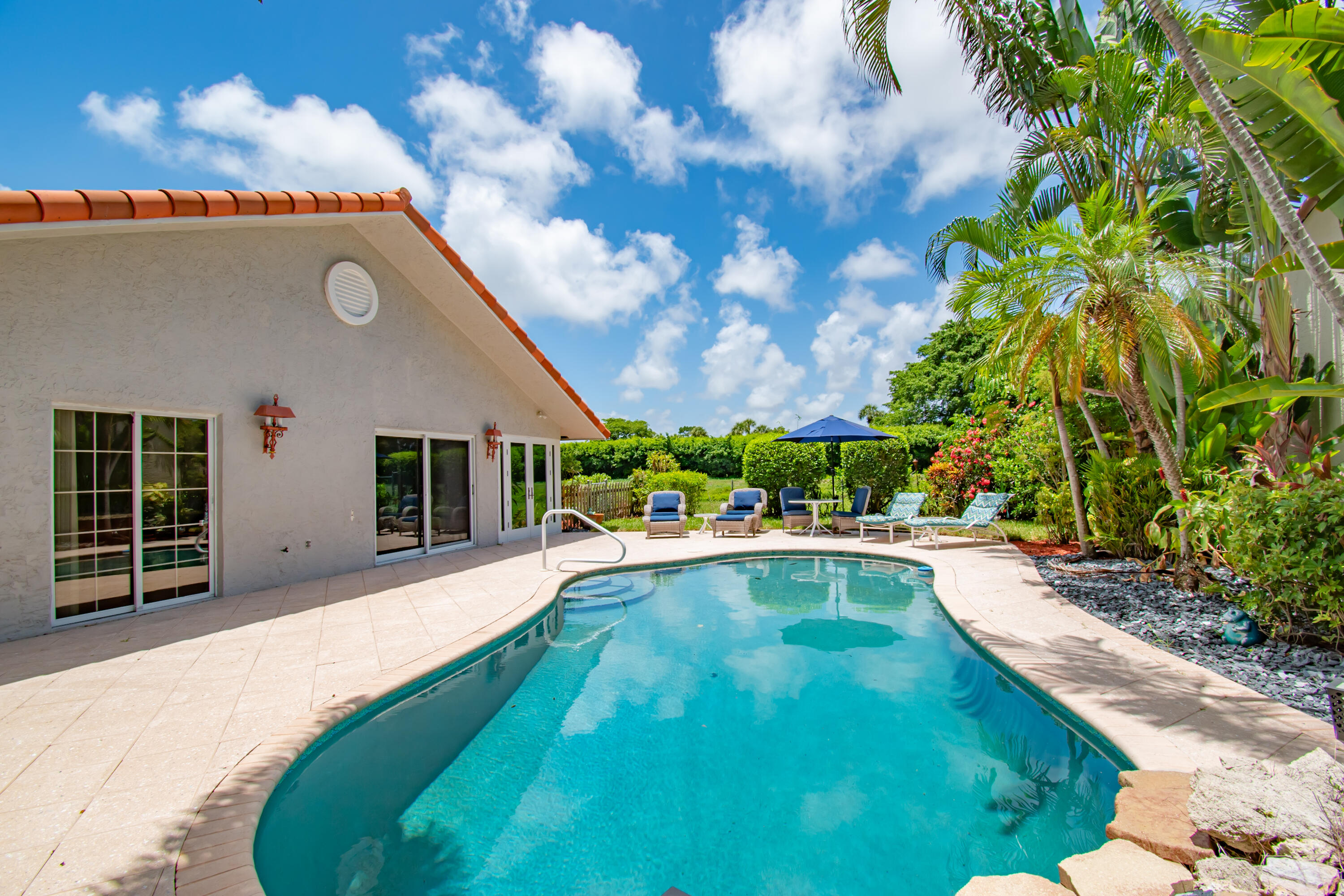 a view of an house with swimming pool and porch with furniture