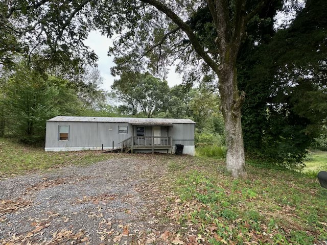 a view of a house with a yard and tree