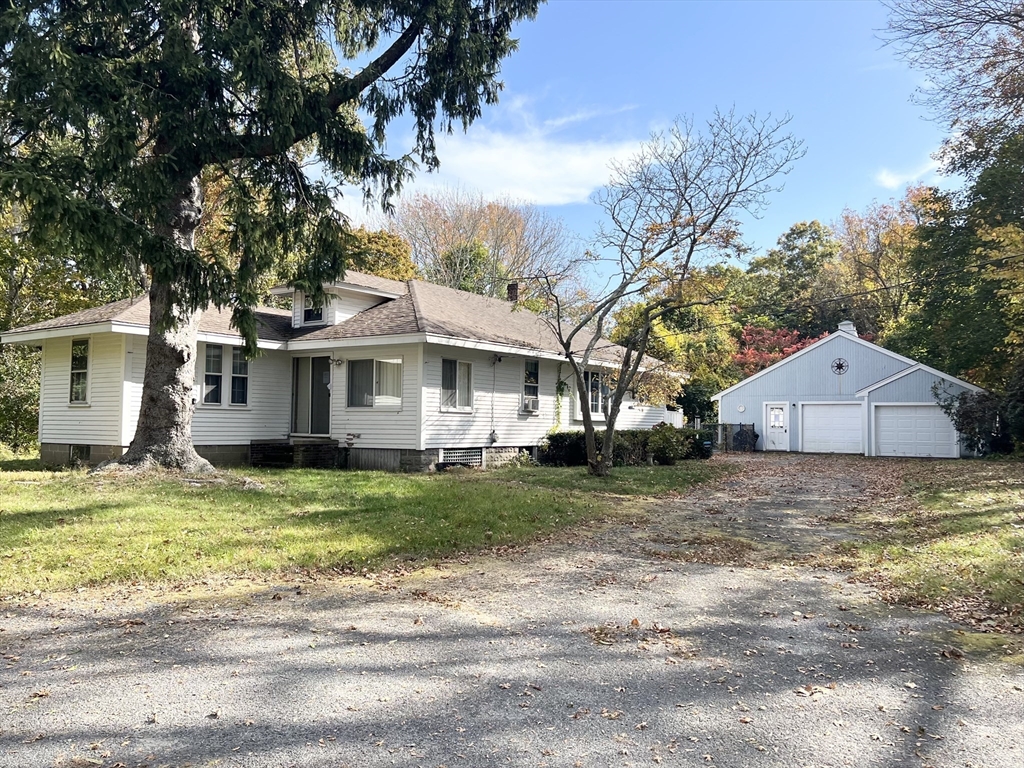 a view of a house with a yard and large tree