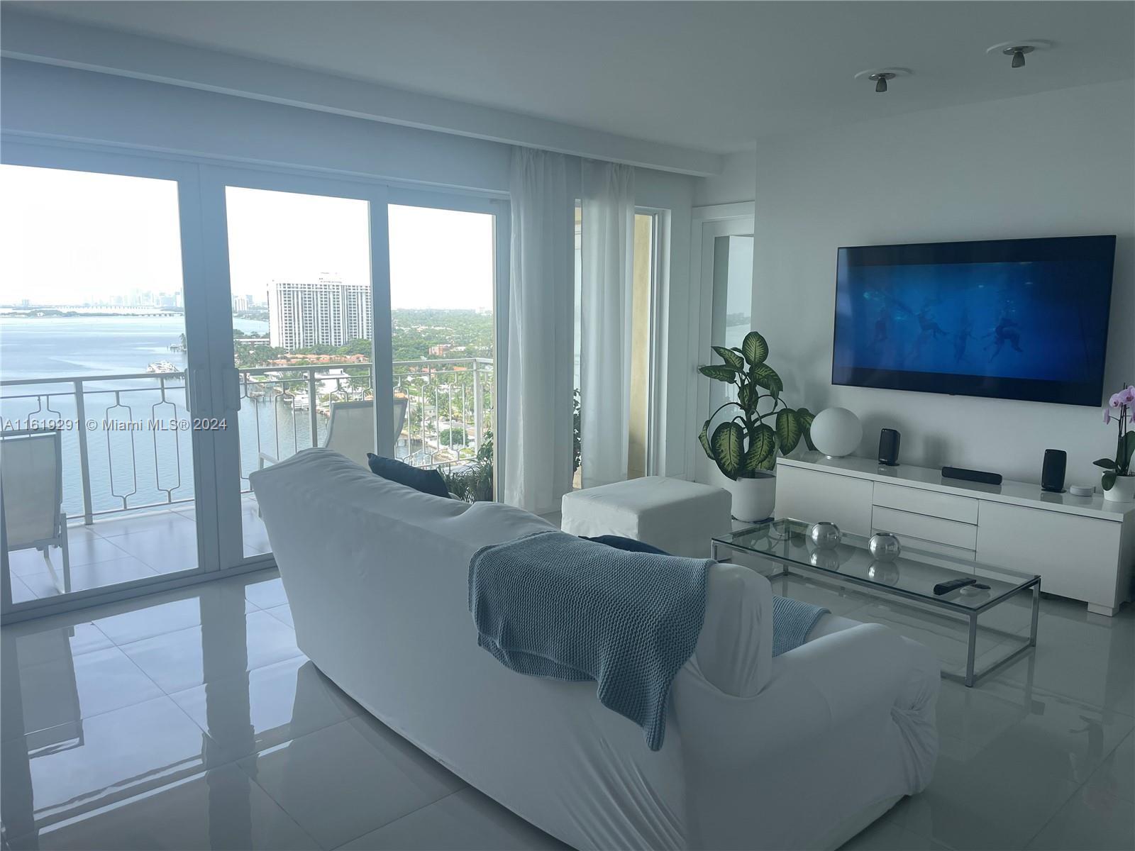 a living room with furniture potted plant and a large window