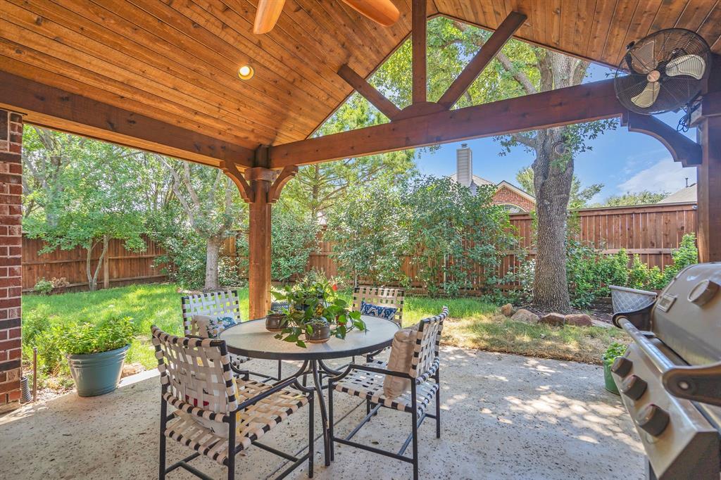 a backyard of a house with a table and chairs