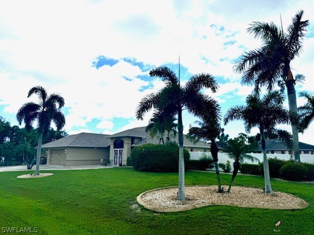 a view of a backyard with a fountain plants and palm trees