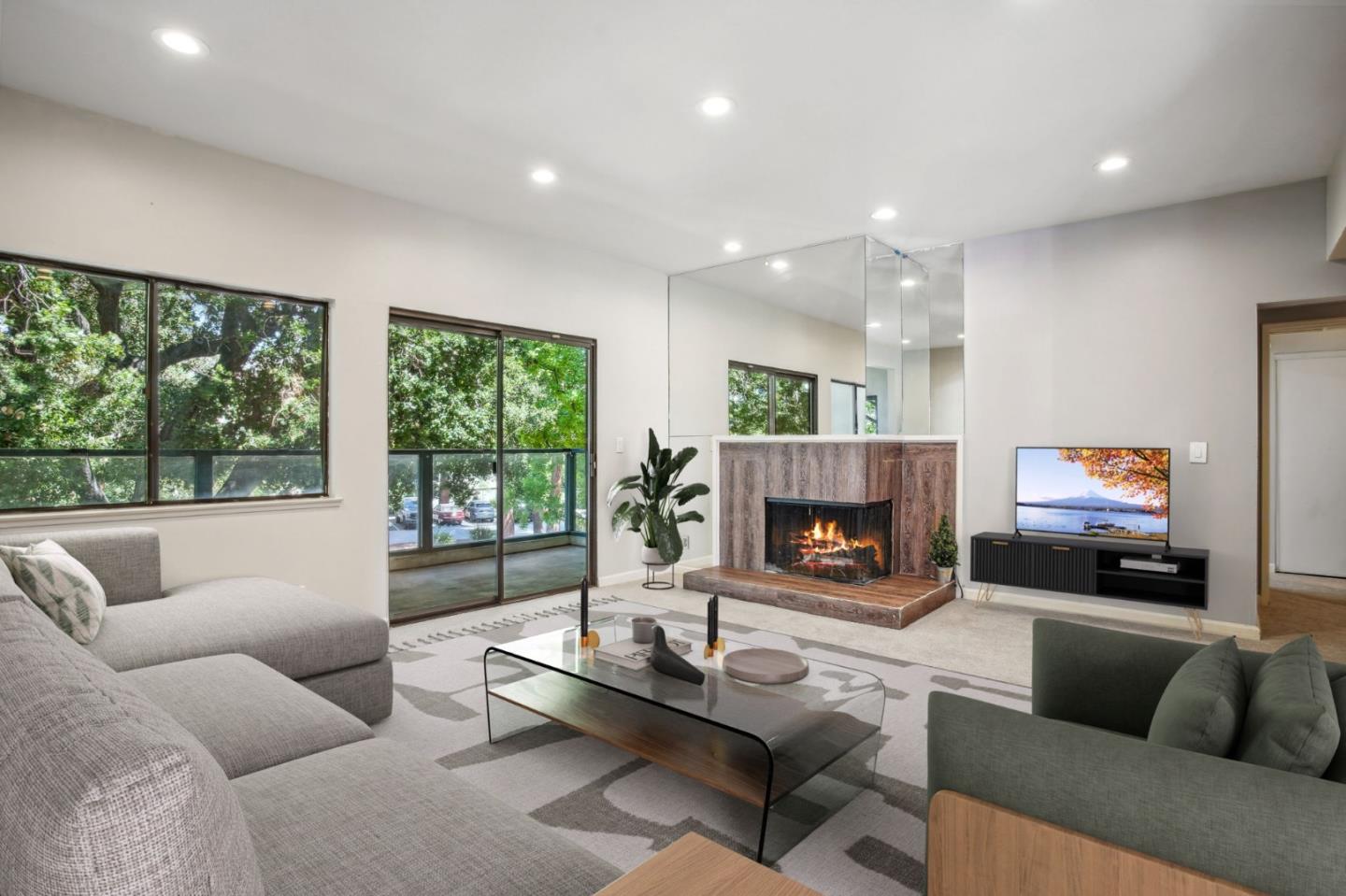 a living room with furniture a fireplace and a large window