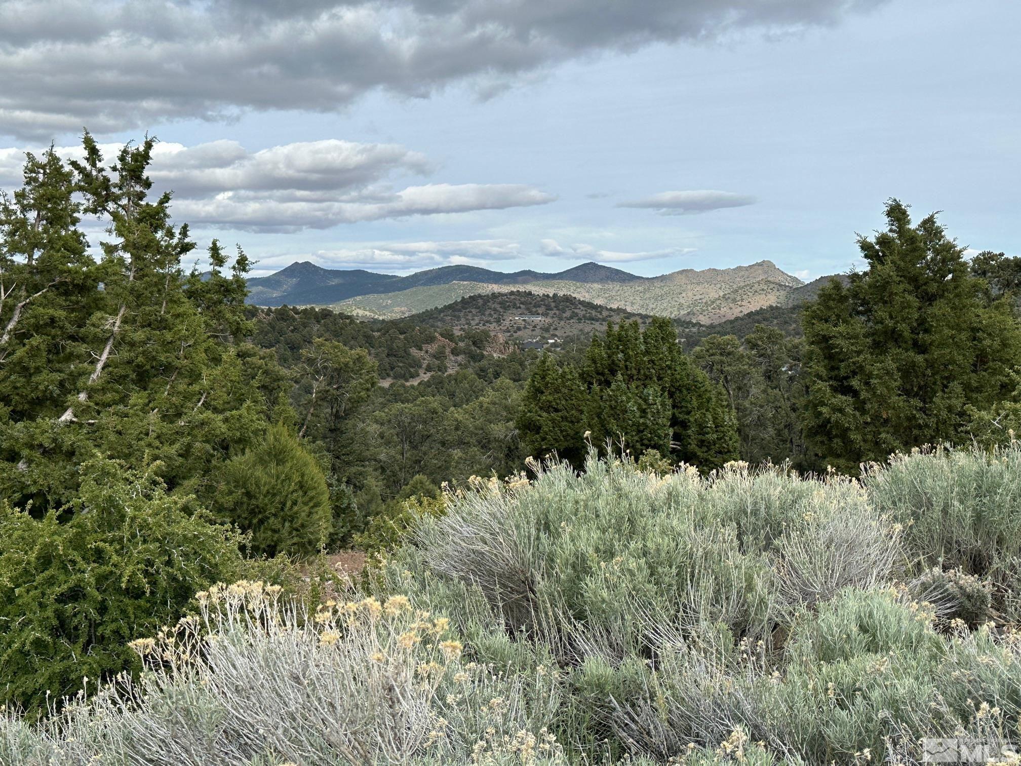 a view of a mountain in the distance in a cloudy sky