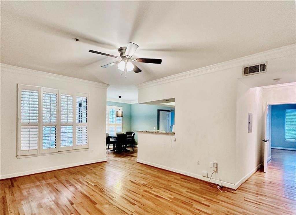 a view of an empty room with window and wooden floor