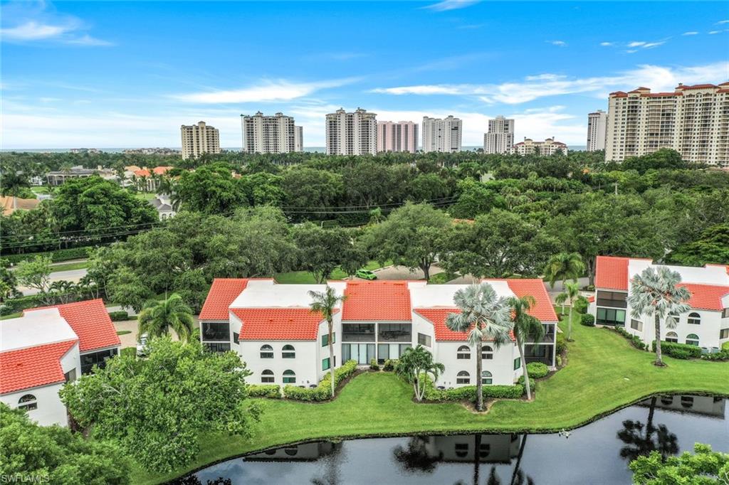 an aerial view of residential houses with outdoor space and lake view