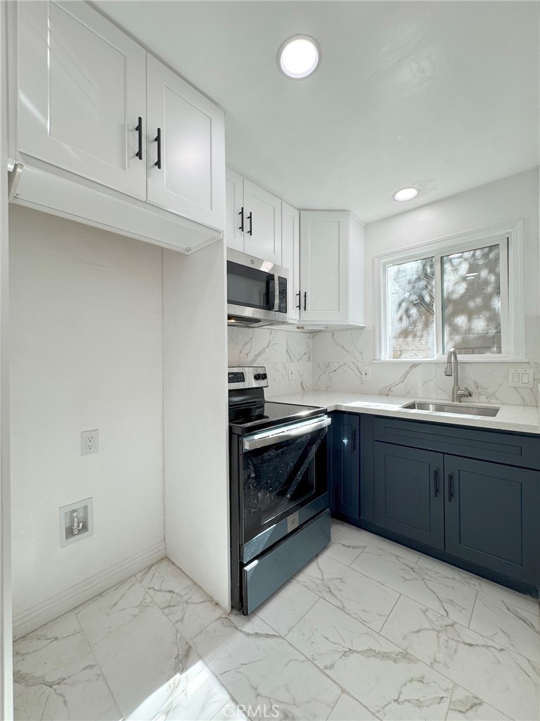 a kitchen with granite countertop a sink and cabinets